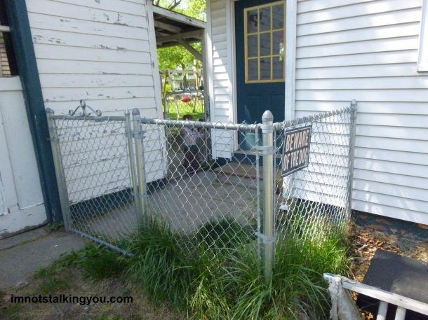 The newest part of the fence, enclosing the backdoor.  See old fence restricting a toddler in the background.